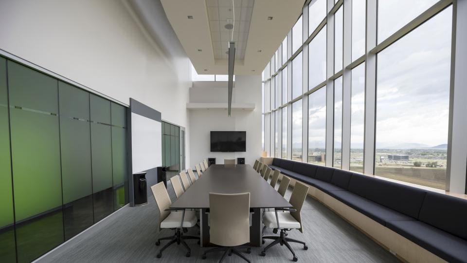 Sala de reuniones con mesa larga y ventanales